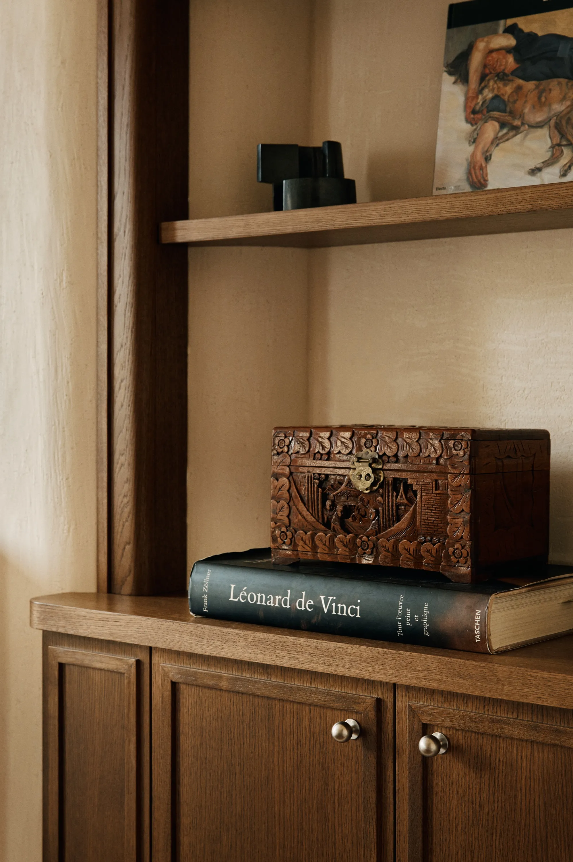 Coffret en bois sculpté posé sur un livre Léonard de Vinci