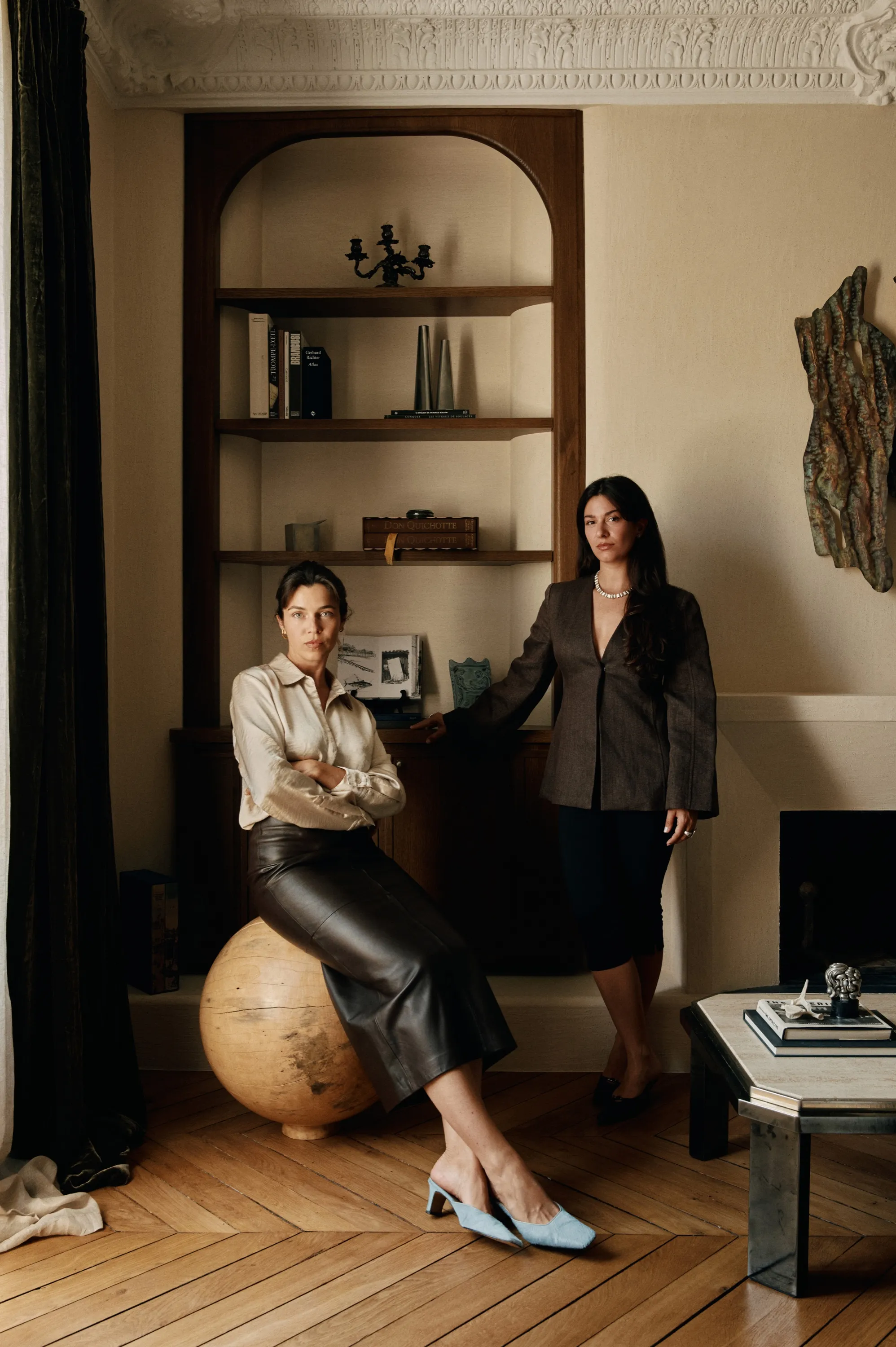 Les deux fondatrices de l’agence dans un intérieur à bibliothèque cintrée